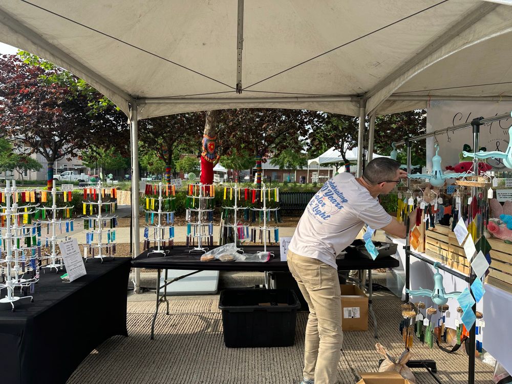 Nathan finishes putting the last wind chimes up at the 3 lazy dogs wind chimes booth.