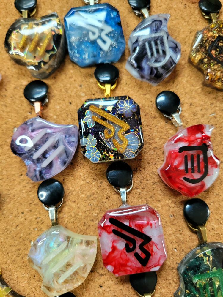 Several jobstones pinned to a corkboard with a floral butterfly machinist in the center