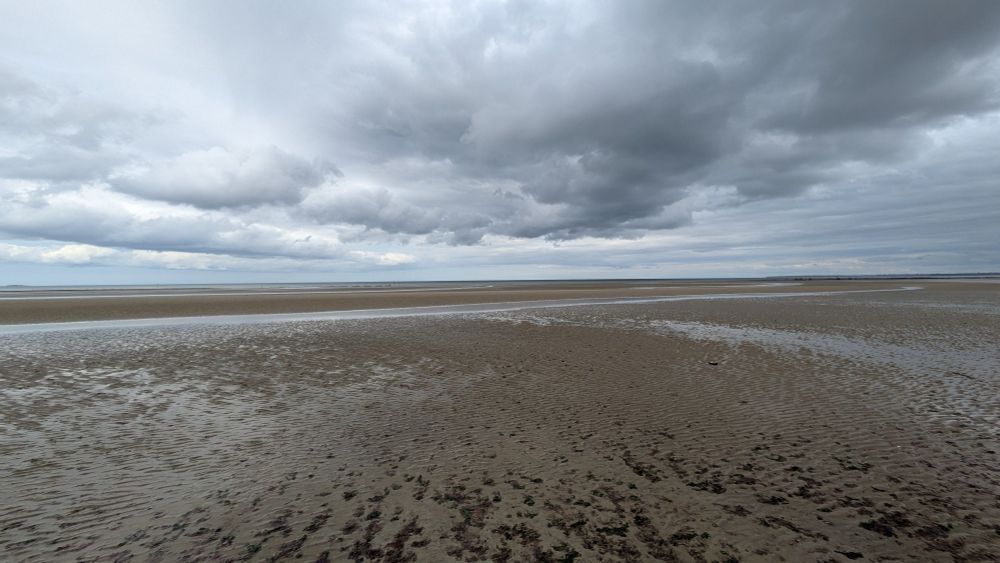 La plage à marée basse, un ciel gris et nuageux en haut, une mer très lointain
Utah Beach où les américains sont venus combattre en 1944 les nazis, qui ont la même idéologie que ceux qui les dirigent maintenant