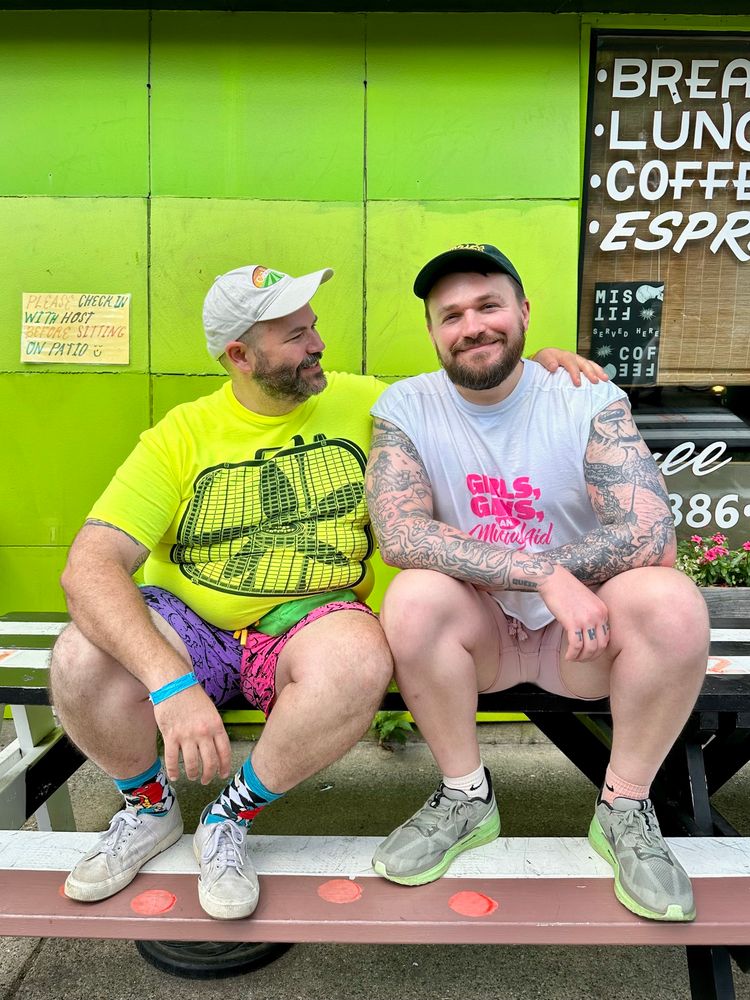 Ben and Chris sit on a picnic table outside of Modern Times