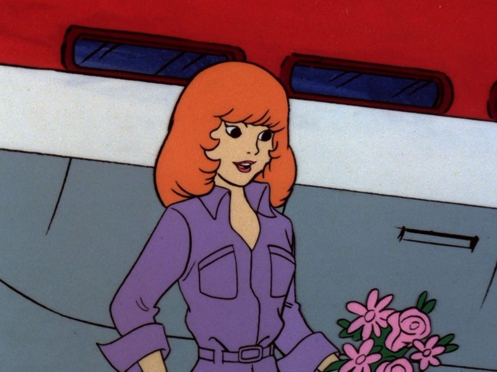 Daphne Blake from Scooby Doo, with a very 80s haircut and a purple jumpsuit