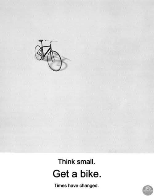 A picture of a bicycle encouraging people to change their thinking and habits. The text says "Think small. Get a bike. Times have changed."