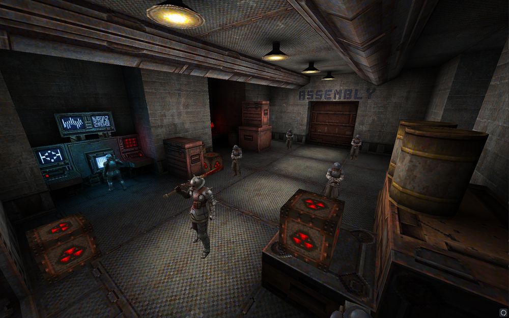 Well lit storage room with some boxes and barrels scattered around it. Blue and red glows from terminals on the side. Text on a wall stating assembly area.