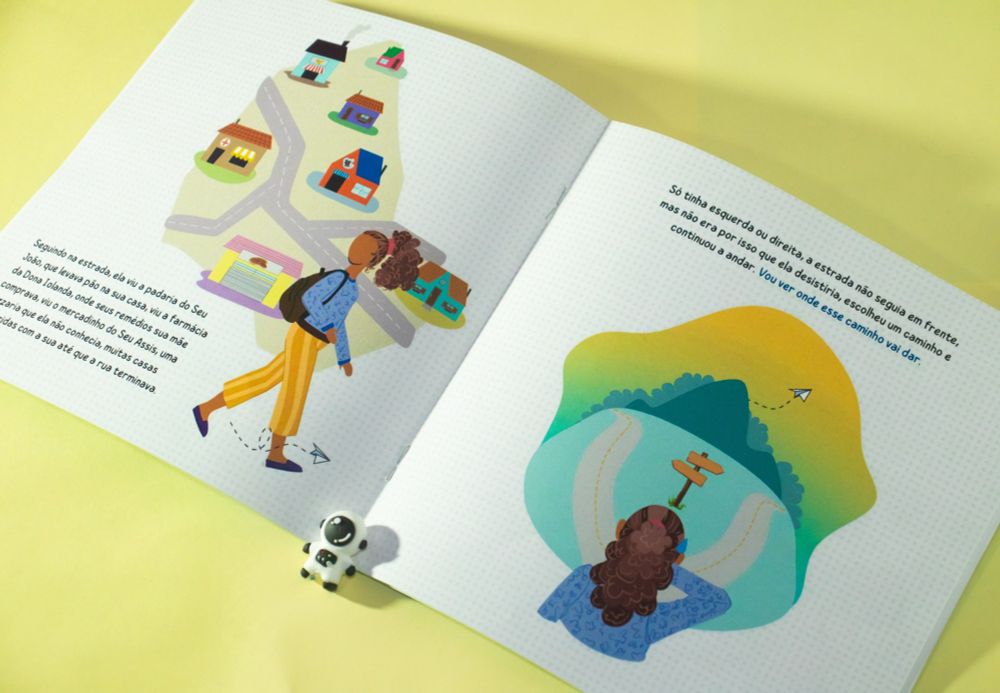 Livro aberto, em uma página uma menina caminhando em frente a um mapa, na outra página a menina parada em frente a uma bifurcação.