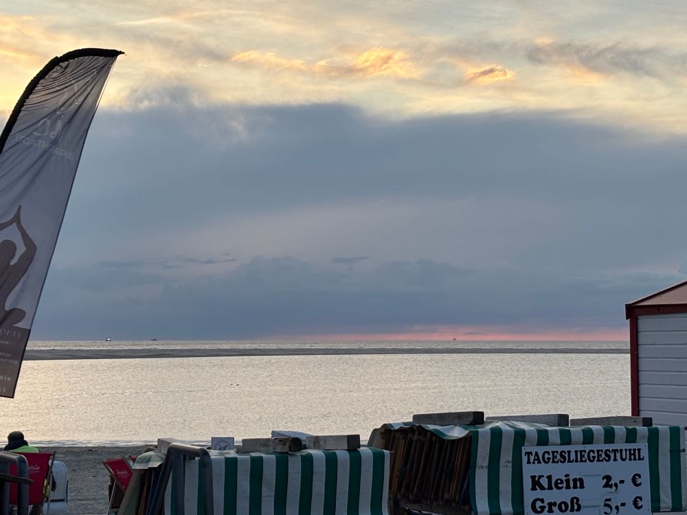 Kein Sonnenuntergang wegen einer Wolkenwand. Ganz unten sieht man einen roten Streifen überm Meer. 