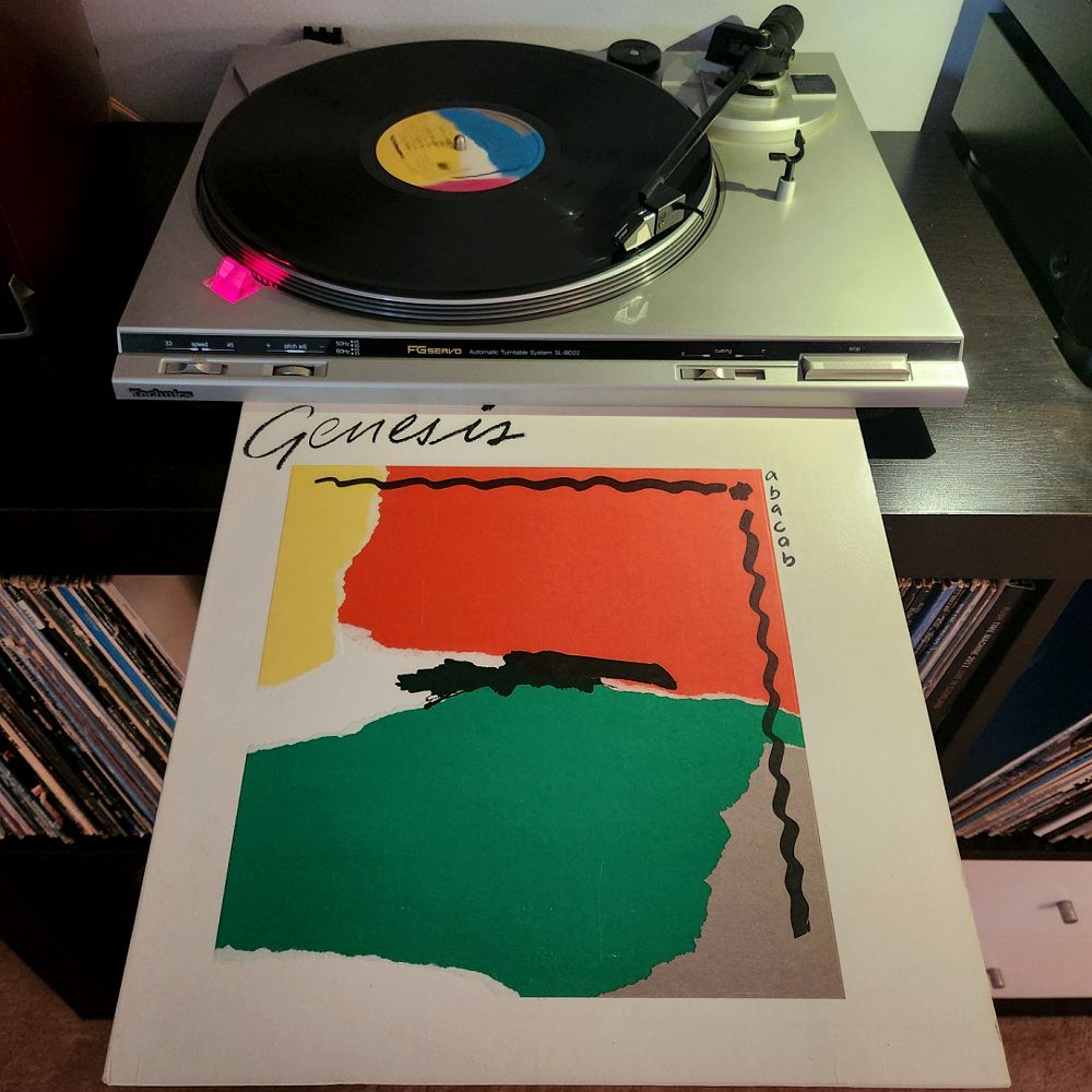 Image depicts the spinning of the 1981 Genesis vinyl album "Abacab" on a turntable along with the cover of the album.