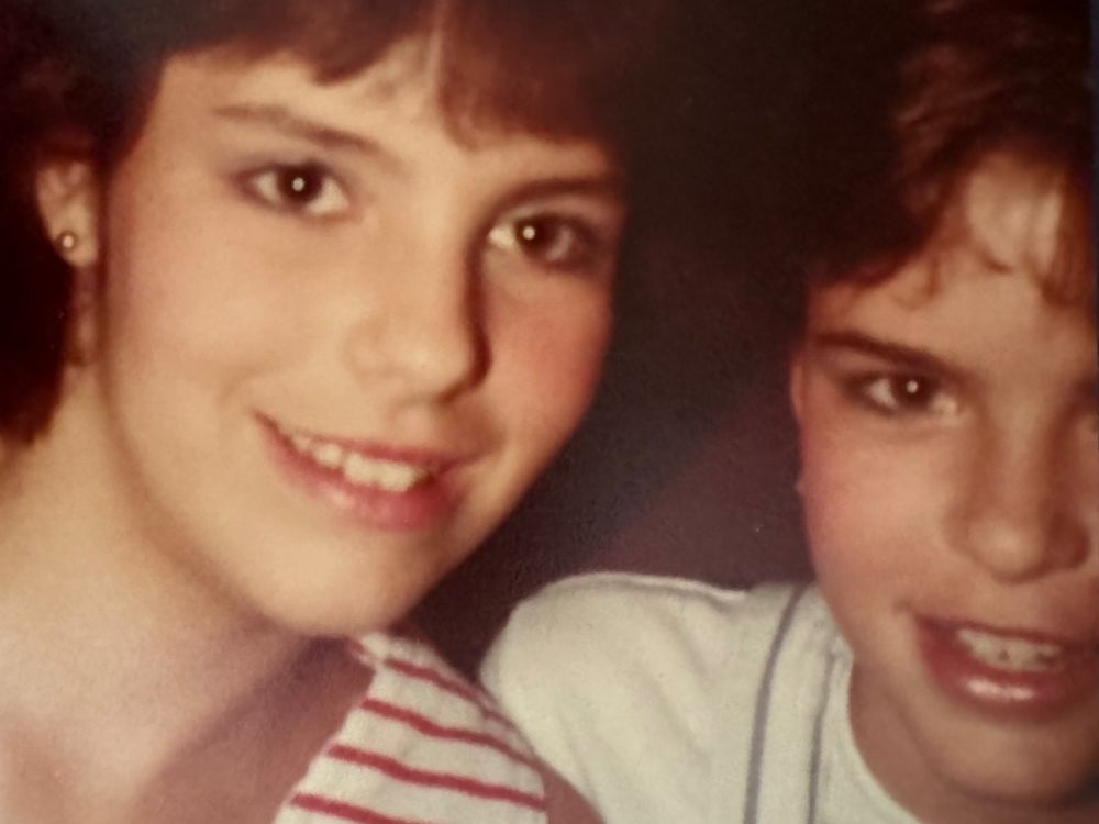 two young teens with feathered bangs and cheap mall makeovers and striped shirts 