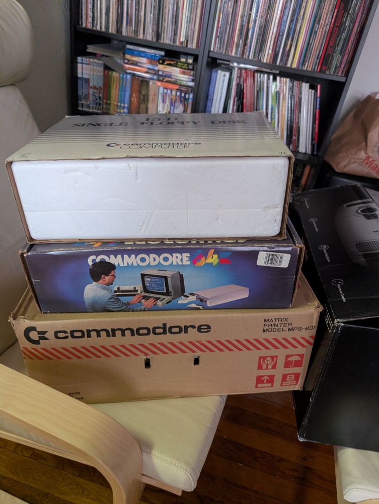 Stack of boxes, bottom to top: Commodore printer, Commodore 64 computer, floppy disc drive