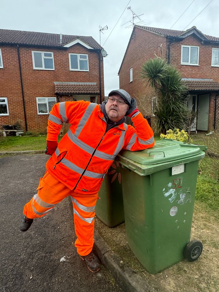 Crew member standing next to bins