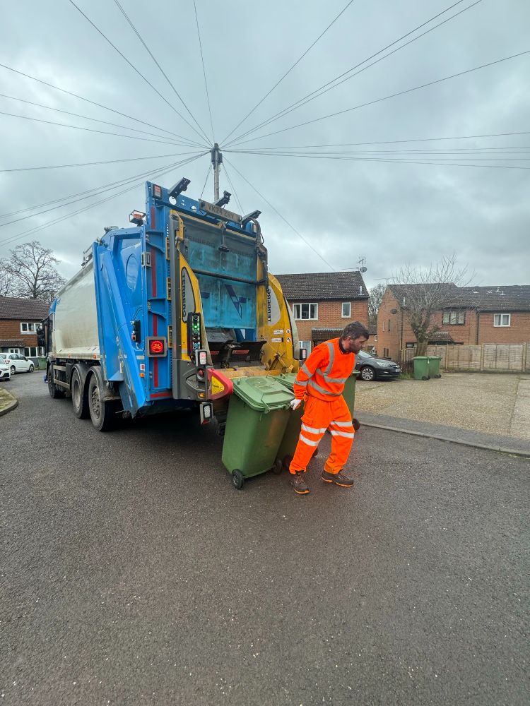 Loader pulling bins away from the back of the bin lorry