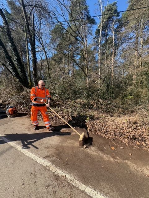 Man sweeping rural road