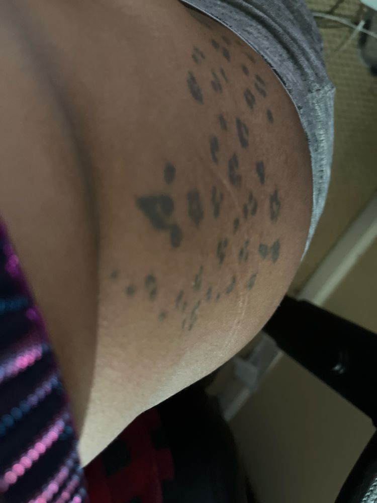 A very bad photo of a leopard tattoo on the right side of a persons body/hip 