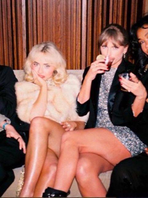 taylor swift at the grammys after party. she is sat on a sofa with sabrina carpenter