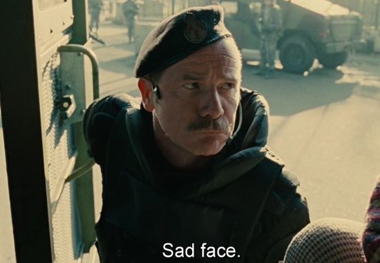 Peter Mullan in "Children of Men" as Syd, refugee camp guard.

He is demonstrating to the main characters how to impersonate new refugees.