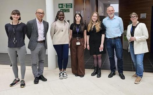 A group of staff and prize-winning students stood in a line, facing the camera, at the PGR Poster Day.