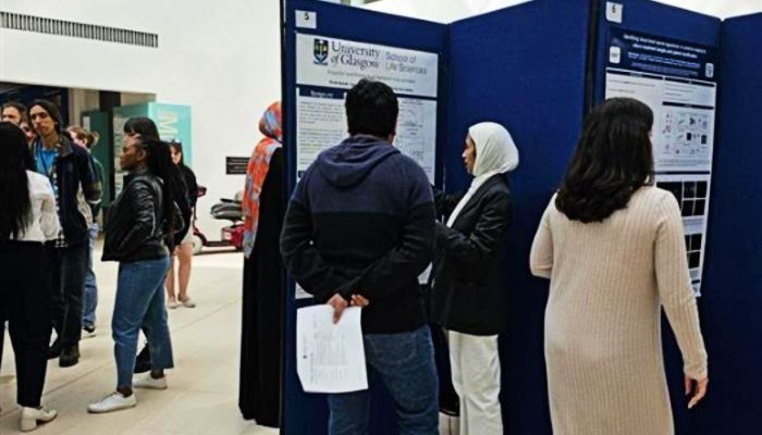 Staff and students mingle and take in poster boards on display at the Sii PGR Poster Day 2025.