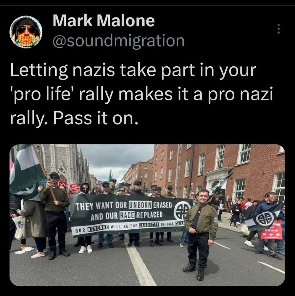 screenshot of post by Mark Malone @soundmigration
.
Post reads "letting nazis take part in your 'pro life' rally makes it a pro nazi rally. Pass it on."
Malone's post has attached image of chuds with flags and a banner  marching. Multiple fags are black and white striped and feature a celtic knot design. The banner, which also has the knot design, reads "They want our emphasis 'unborn' erased and our emphasis 'race' replaced". Below that "our emphasis 'revenge' will be the emphasis 'laughter' of our emphasis 'children'."
The chuds wear grey caps and sun glasses, and one especially smarmy chap wears a remarkably brownshirty get-up with an olive shirt, black tie, combat boots, and a somewhat armband-looking celtic knot design on the sleeve.
[alt-text concluded]