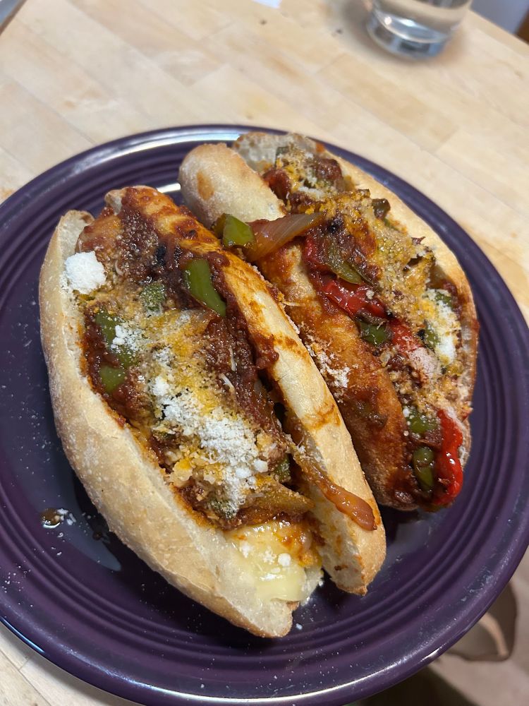 Two sausage and peppers sandwiches on hoagie rolls 