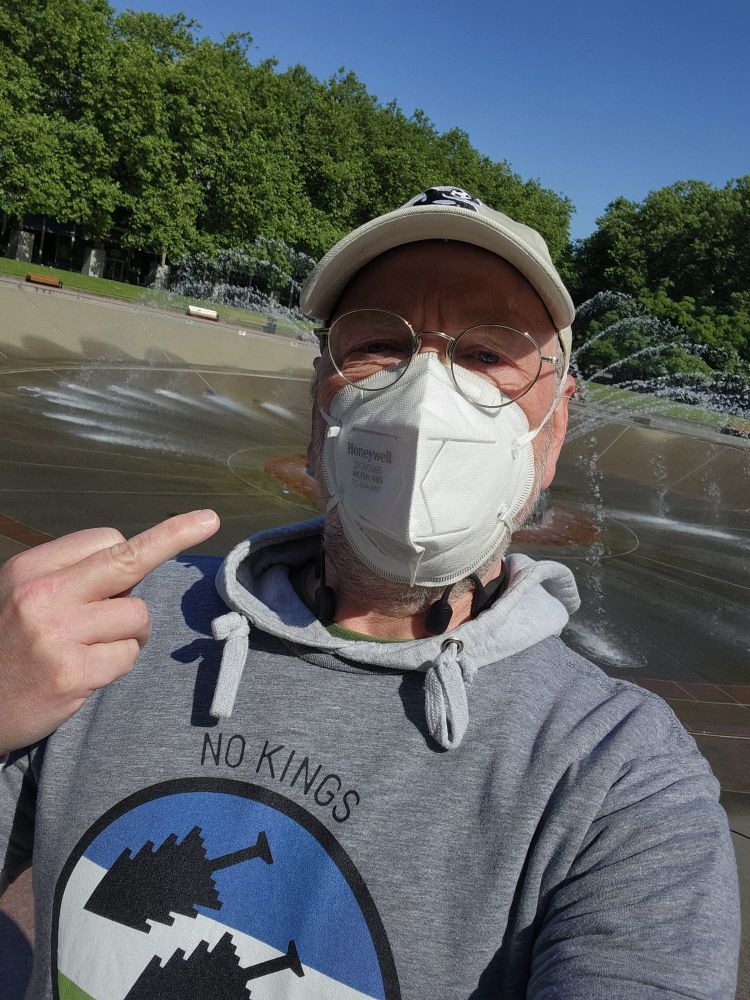 A refined gentleman with a "No Kings No Tyrants" Cascadia-themed Iron Front-styled shirt with the universal hand gesture of defiance.