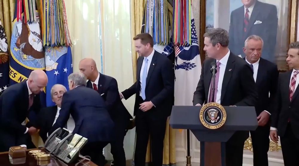 A man faints in the Oval office and RFK Jr runs away while everyone else rushes towards the man to help him.