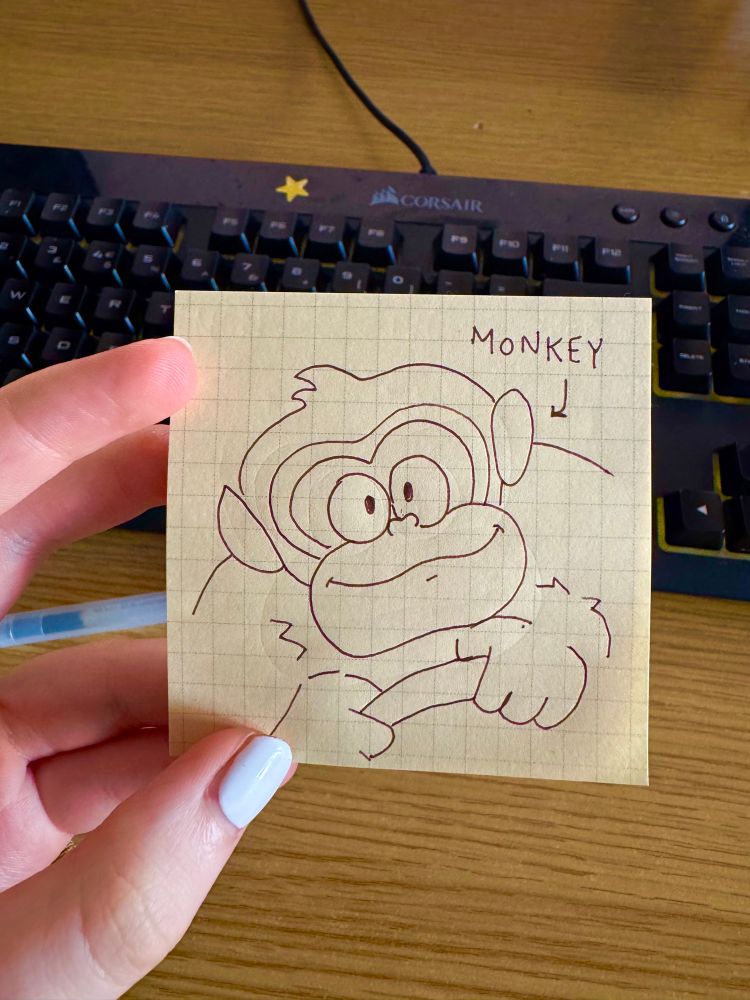 a drawing of the new donkey kong character design on a yellow grid post it note. An arrow labelled “monkey” points to him. My keyboard can be seen in the background 