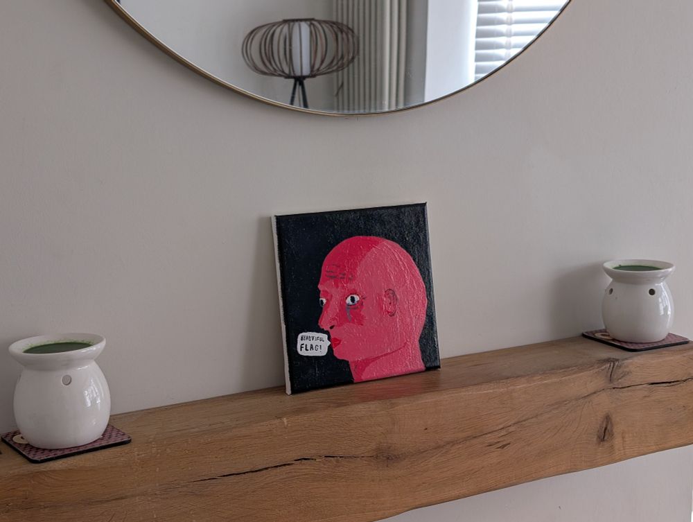 Beautiful painting that is a raw gammon pink man saying "beautiful flag" on a black background. The male has no hair or eyebrows but does gave eyelashes, he is weeping. Stunning. 