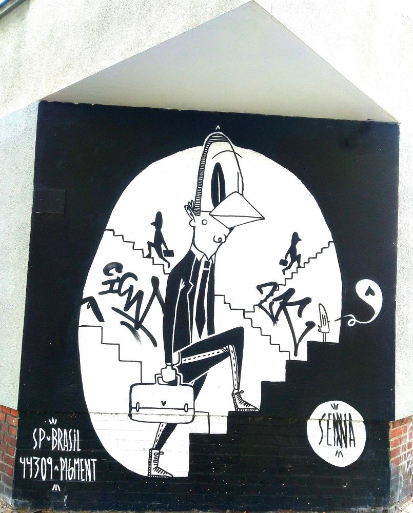 Ein Graffiti an einer abgeschrägten Hauswand, mehrere sich überlagernde Treppen werden von Aktentaschen Männern bestiegen 