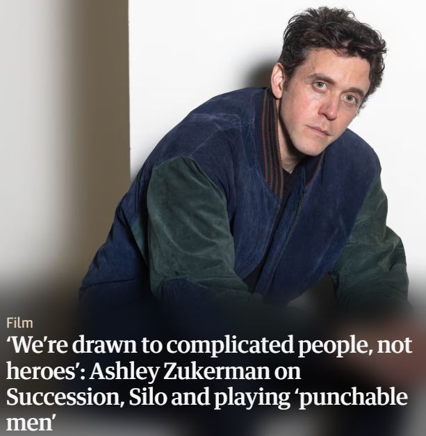 A photo of actor Ashley Zukerman looking slightly pensive, slightly angry with the headline superimposed "We're drawn to complicated people, not heroes": Ashley Zukerman on Succession, Silo and playing 'punchable men"
