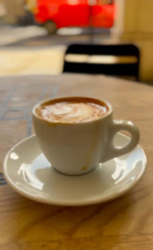 a cup of cappuccino on a saucer on a table