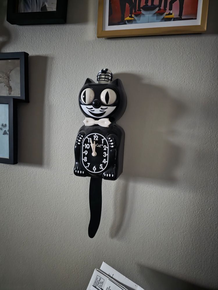 A cat clock hanging on the wall, it is not creepy.
