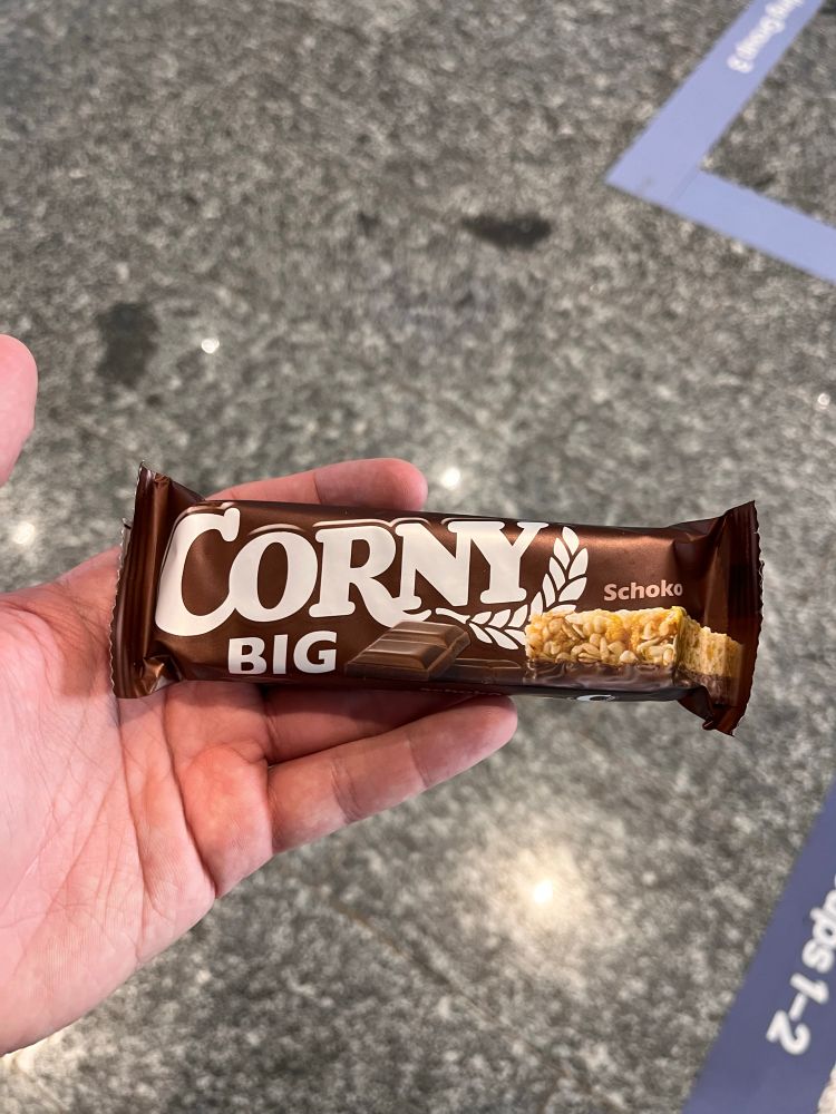 Photo of a hand holding a a package that says - Corny Big