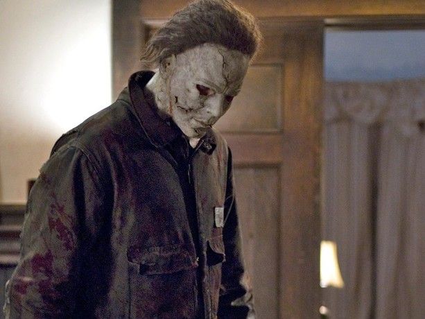Michael Myers (Tyler Mane) stands in a home and stares at something on the floor in Halloween (2007)