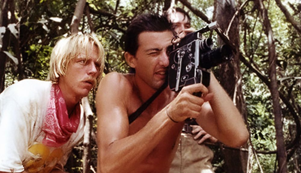 Jack (Perry Pirkanen), Mark (Luca Barbareschi) and Alan (Carl Gabriel Yorke) film in the jungle in a scene from Cannibal Holocaust.