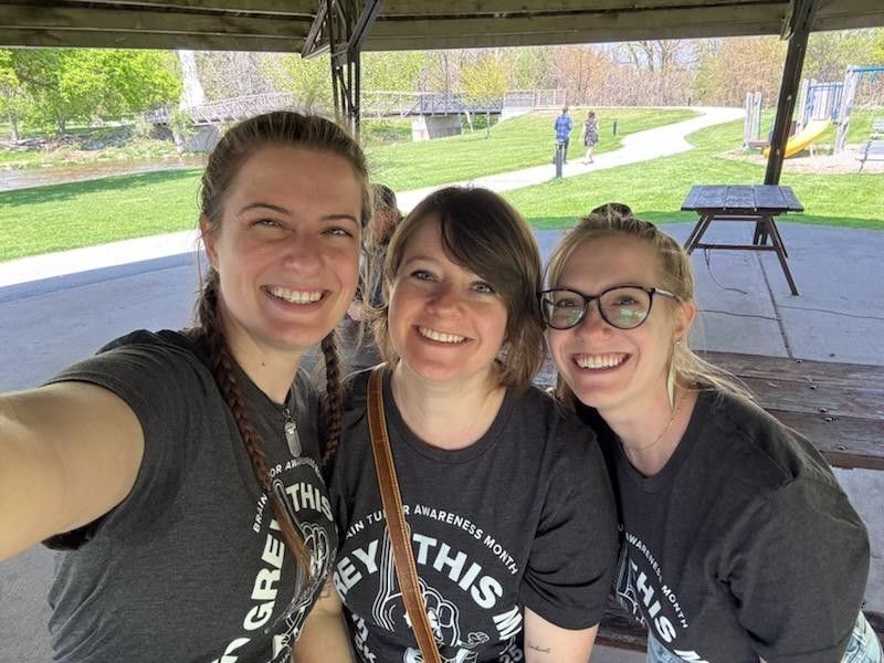 Selfie of three girls standing side by side in matching grey tshirts. 