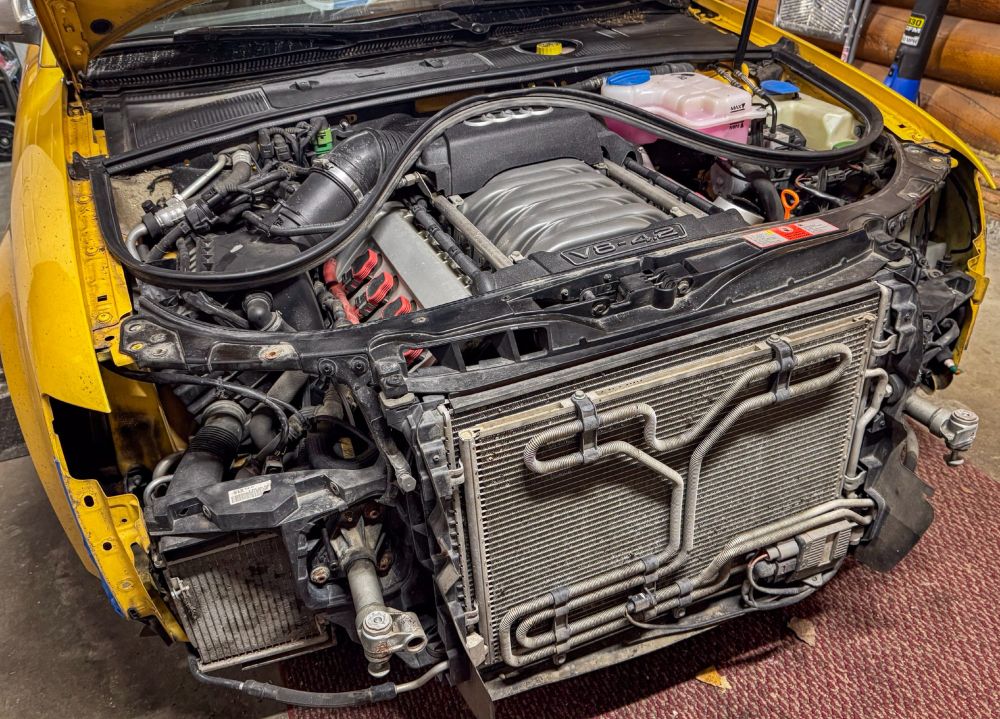 Audi S4 with the bumper removed and front end pulled out to "service position" in order to get a FEW inches of gap  to maybe get at the accessory belt. 