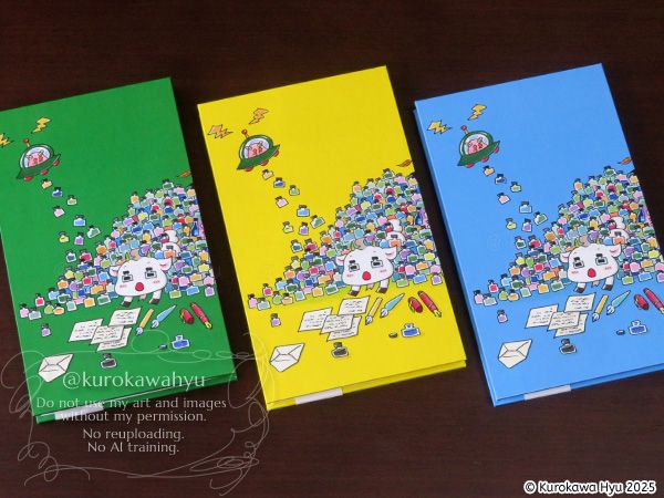 黒川ひゅうオリジナルインク帳『蛇腹deいろあつめ』が3つ並んだ写真。絵柄は、インク瓶に埋もれているヤギくんで、背景の色が、左から、緑、黄色、水色になっている。