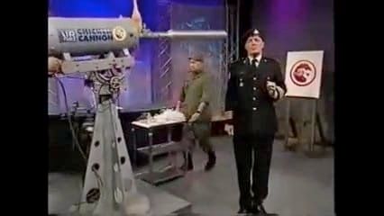 The royal canadian air farce chicken canon, a large air cannon being loaded with a chicken while military looking types stand around it posing. 