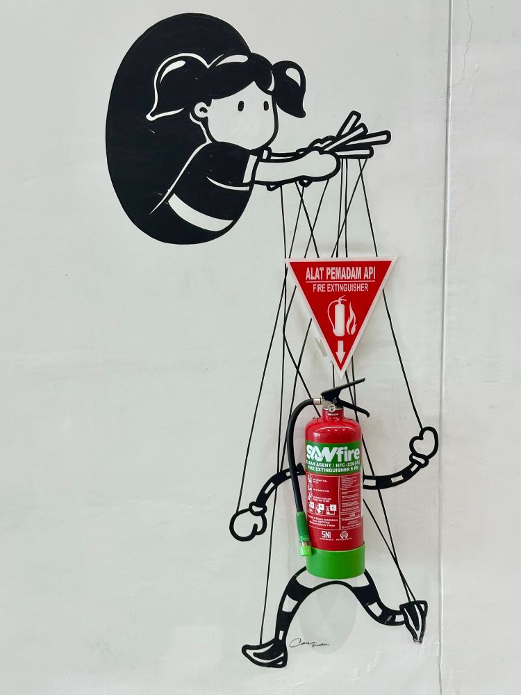 A fire extinguisher with a drawing as if it’s a puppet