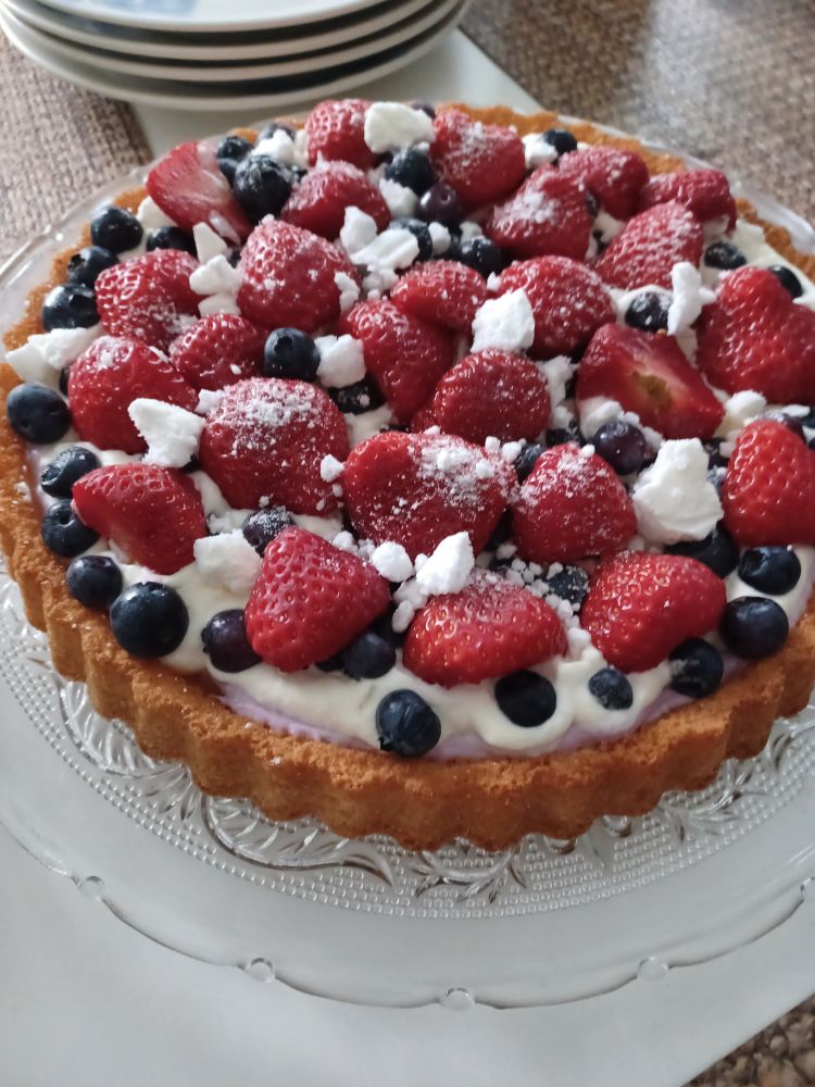 Cake with strawberries and blueberries on cream topping 