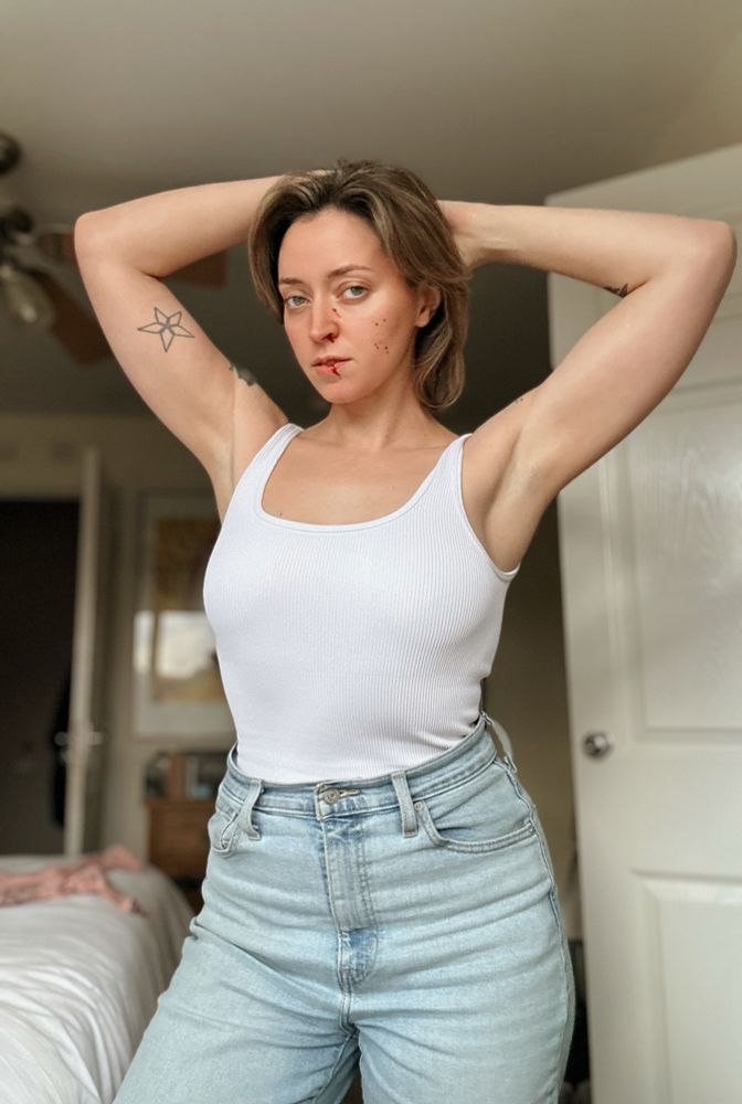 Me wearing a white tank top with fake blood on my face but this time I’m lifting my arms off to show the DEFINITION 