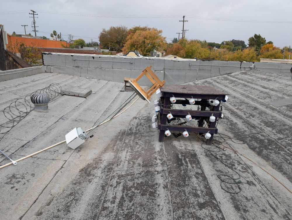 A Meshtastic node laying on the roof with a snapped antenna, having fallen off the structure it had previously been sitting on.
