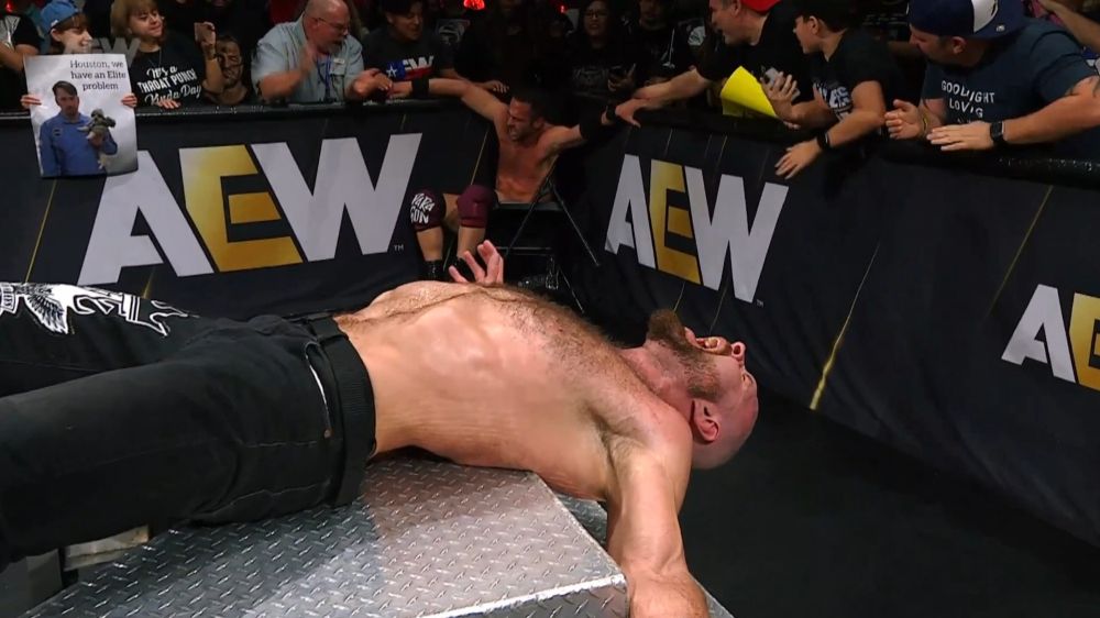Jon Moxley bent painfully over steel steps.