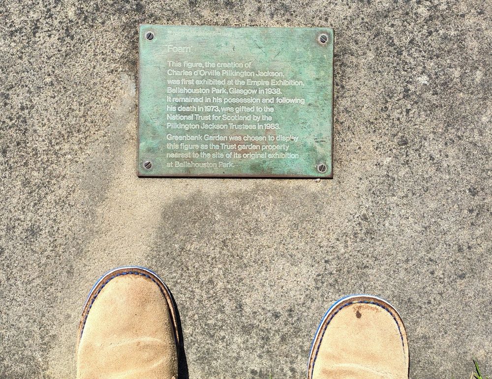 Picture of the plaque describing 'Foam'. Charles d’Orville Pilkington Jackson, the sculptor of the equestrian statue of Robert the Bruce at Bannockburn, created Foam, a bronze water nymph, for the Glasgow Empire Exhibition in 1938. Other mythical creatures at the exhibition surrounded the statue, all sold except for Foam, which Pilkington Jackson kept. After his death, the statue was moved to Greenbank, the nearest garden to Bellahouston Park, where the exhibition occurred.