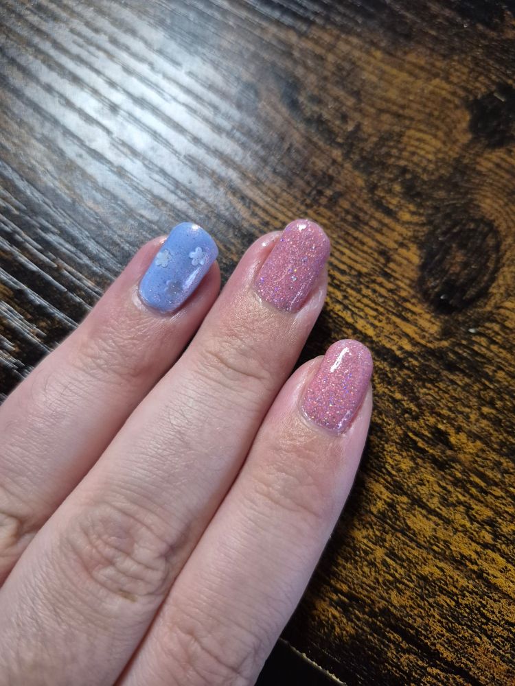 Blue and pink nail art with silver flowers on the ring finger nail