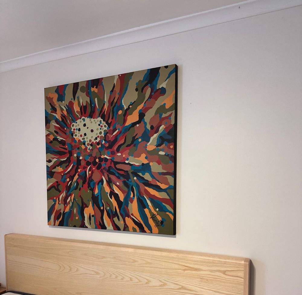 Abstract painting on top of a bed head.