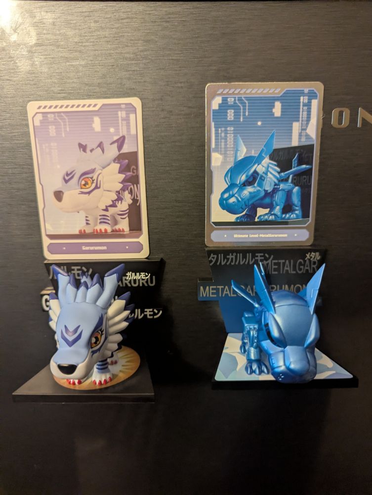 Two PopMart fridge magnet figurines. Left, the Digimon garurumon, right, an all blue rare metalgarurumon