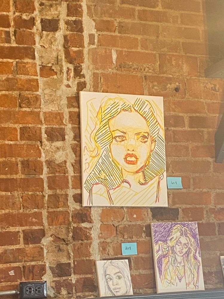 Art on a wall of the local cafe (which I got hehe) by _vagabond_voyages on Instagram of a girl with voluminous dark hair and pretty red lips sneering (?)