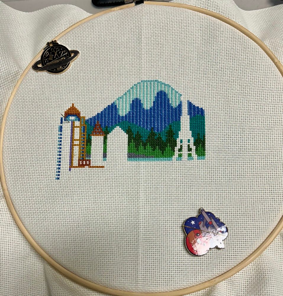 Incomplete cross stitch of a whimsical Seattle skyline.  Progress on a building on the left side.