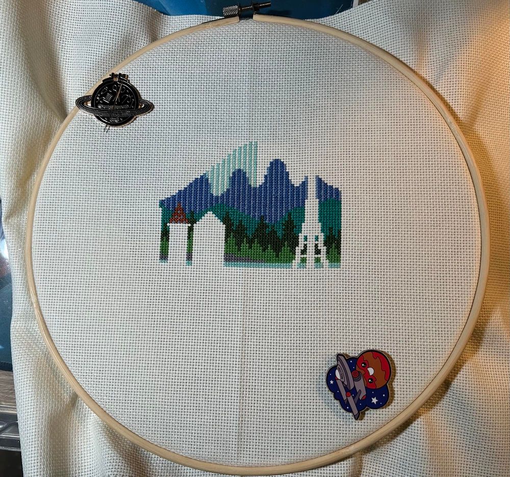 Incomplete cross stitch of the Seattle skyline. Progress on Mt Rainier.