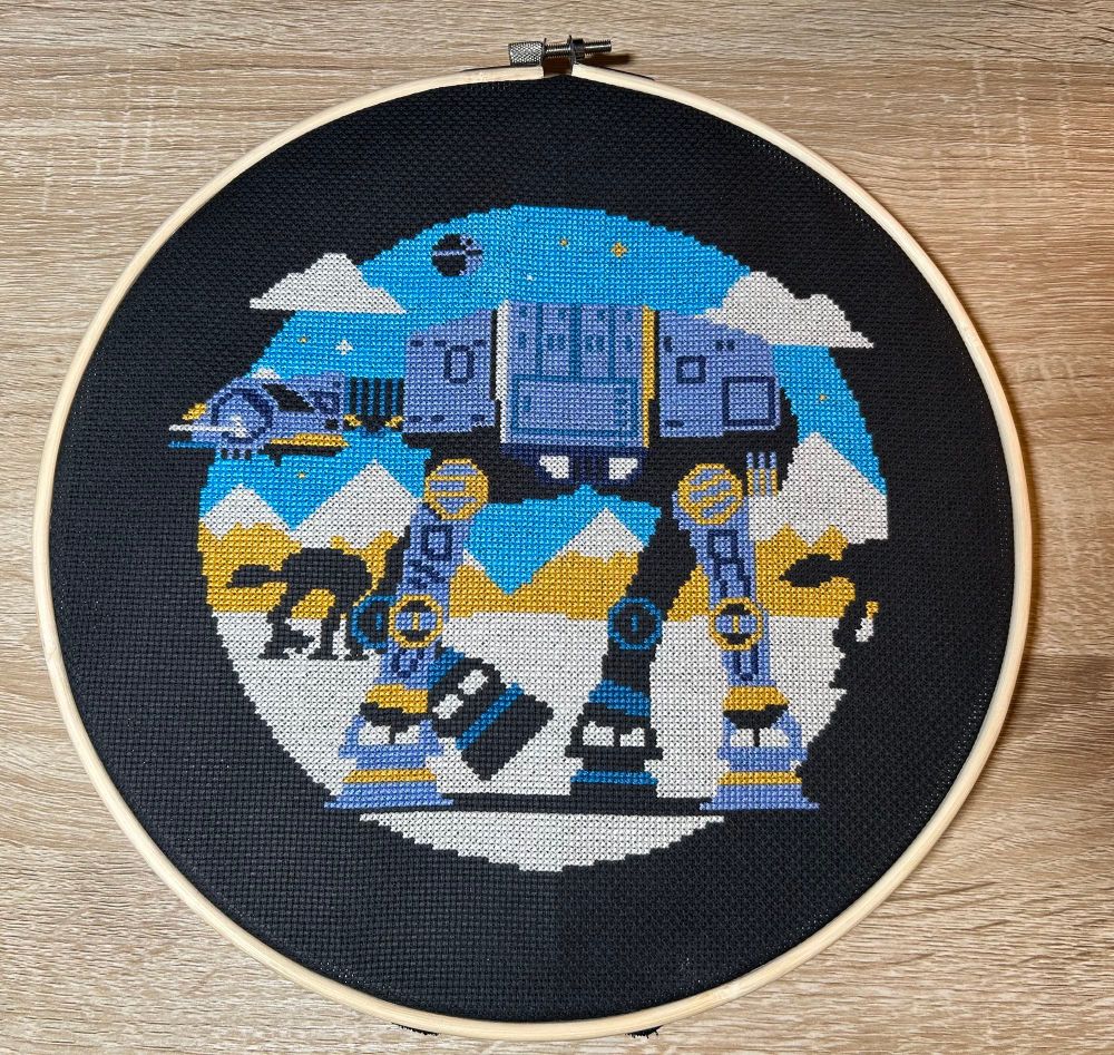 Completed cross stitch of three minimalist AT-AT walkers from Star Wars.  Original design by DKNG Studios.